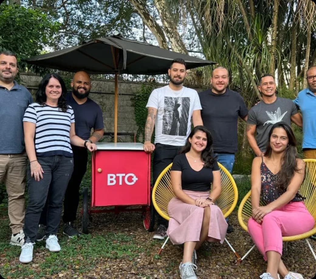 Equipe da BTO+ reunida ao ar livre ao lado da bike de carga vermelha BTO